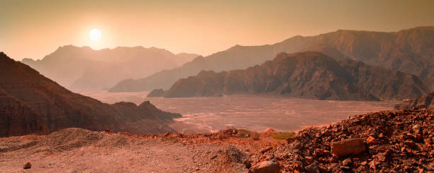Landscape on the panet Mars with mountain range and sun Landscape on the panet Mars with mountain range and sun. In reality the photo was made in the desert of Musandam, Oman, near the city of Khasab. mars stock pictures, royalty-free photos & images