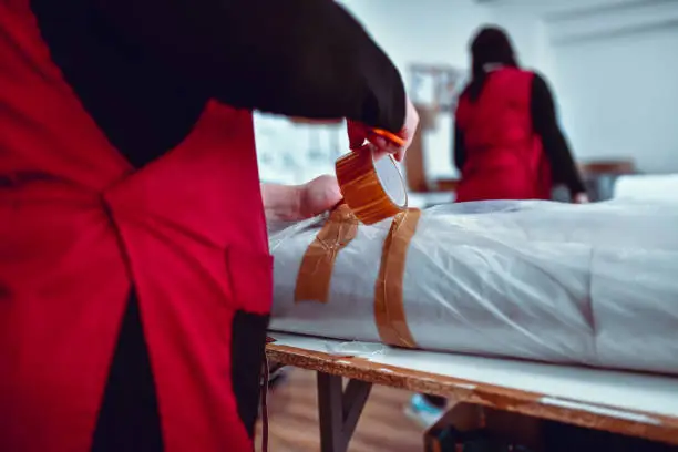 Photo of Textile Workers Taping Up Rolled Materials