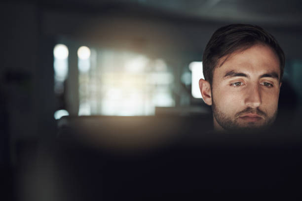 istock Shot of a young businessman using a computer in a modern office at night 1313856396