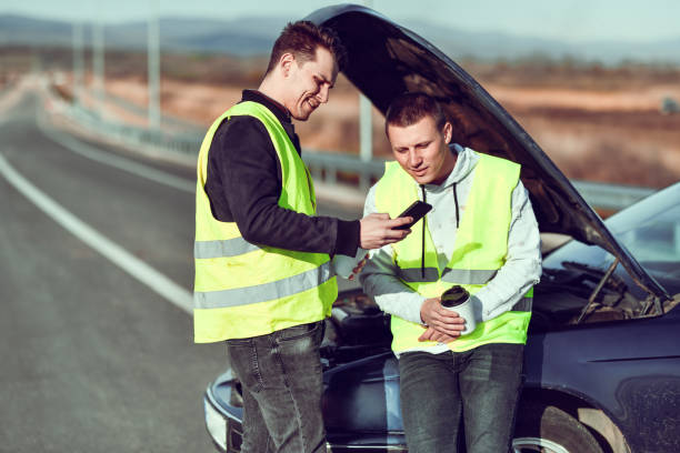 istock Males Looking For Tow Service Number In Smartphone While Having Car Engine Malfunction 1313857411