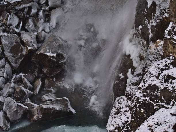 vista de cerca del fondo del agua cae hundafoss en skaftfaell cerca de la carretera de circunvalación, parte del parque nacional vatnajökull, en el sur de islandia en la temporada de invierno con agua de pulverización y rocas congeladas. - europe high angle view waterfall water fotografías e imágenes de stock