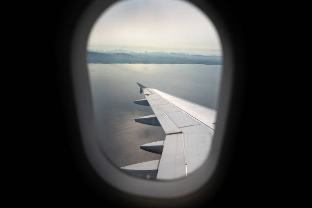 istock Looking through the window frame of airplane with ocean background. 1313860723