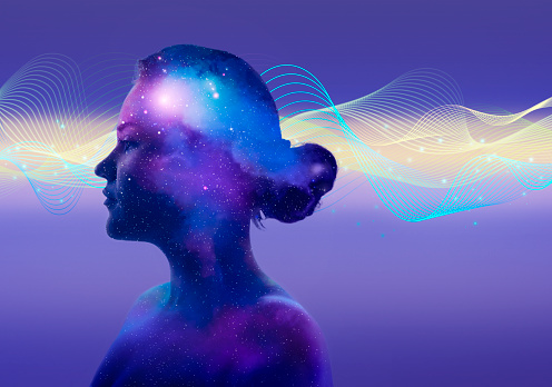 Brain activity illustrated as a young woman portrait merging with the universe and digitally generated waves.