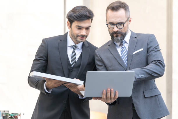 istock Handsome businessman and Engineer attractive. Businessman and attractive Engineer talking and holding laptop and solar panel at outside office. 1313872542