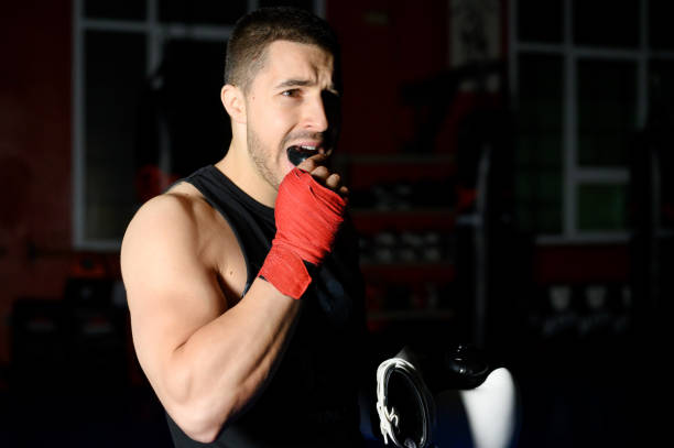 istock Boxing fighter putting on mouthguard. 1313875388