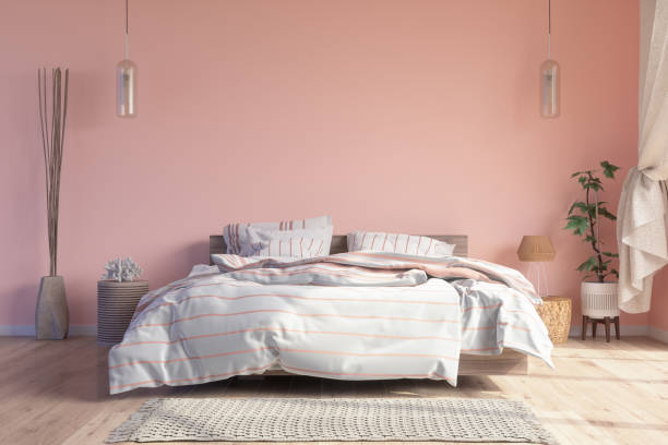 interior del dormitorio con cama desordenada, luces colgantes, suelo de parquet y fondo de pared de color rosa - queen size bed fotografías e imágenes de stock
