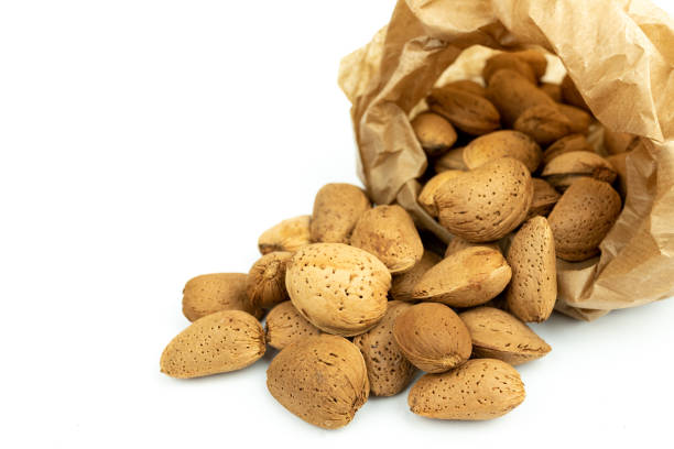 istock bunch of almonds and a kraft paper bag on white background 1313877531