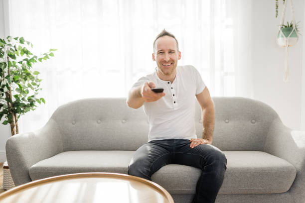 istock Man with remote control on the sofa at home 1313880924