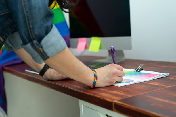 컬투라 lgbtqia. 성소수자 액세서리로 사무실에서 일하는 여성. - gay pride wristband rainbow lgbt 뉴스 사진 이미지