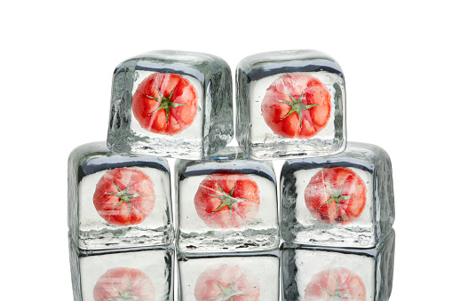 Tomato inside of dry ice cube isolated on white background
