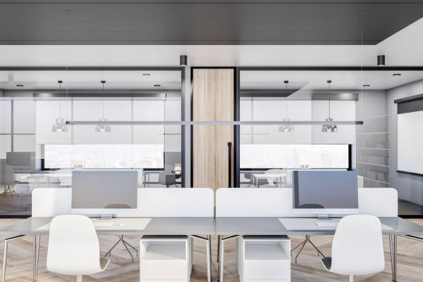 istock Modern light coworking office design with glass partitions, desks with computers, white walls and wooden floor 1313883247