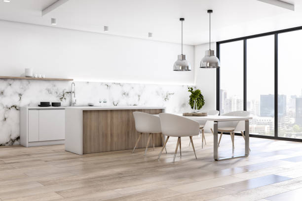 istock Eco style interior kitchen with light marble walls, wooden floor and countertop, white table and chairs and city view from big window 1313883301