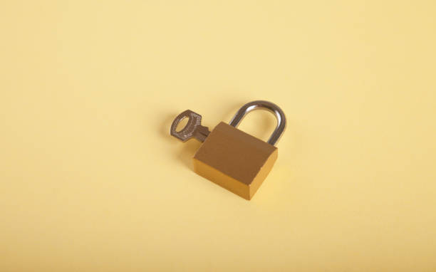 istock Padlock and key isolated on yellow background. 1313883651