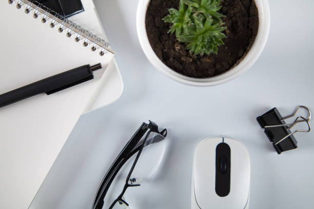 istock White office desk table with blank notebook, business supplies. Top view. 1313883888