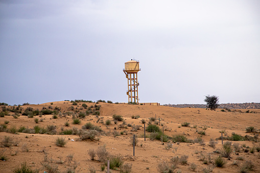 big water tank in desert against dramatic sky in jaisalmer.