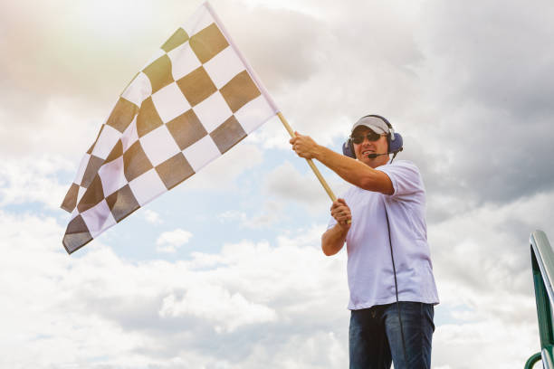 homem acena uma bandeira quadriculada - checkered flag flag the end motorized sport - fotografias e filmes do acervo