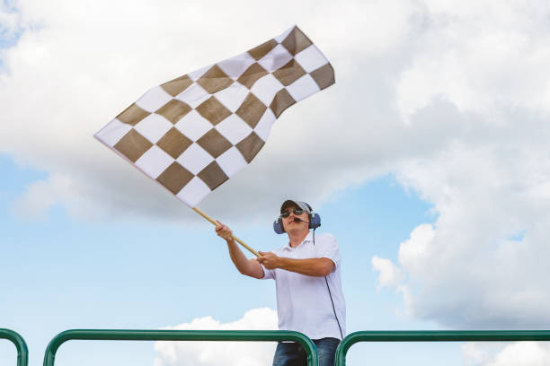 l’homme agite un indicateur à la caisse - flag checkered flag sports race checked photos et images de collection