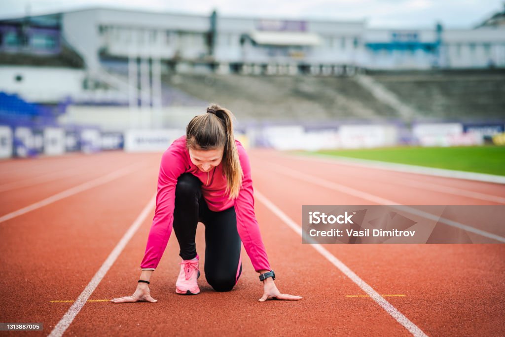 Ready...go! Young caucasian athlete at the stadium. Jogging / Active lifestyle concept. University Stock Photo