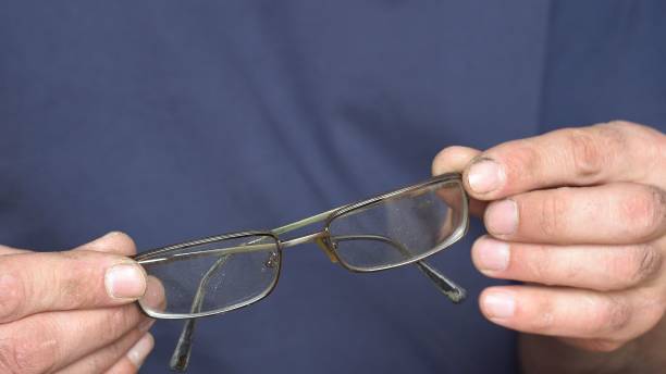 istock Broken old glasses in male hands 1313887177