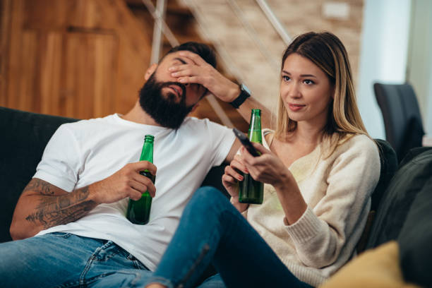 istock Couple drinking beer at watching television at home 1313888106