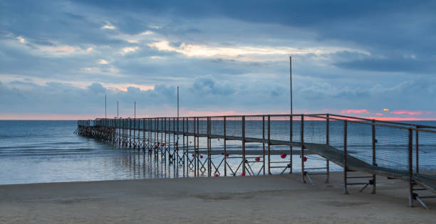 istock dock at rivazzurra beach (Rimini/Italy) in the morning light; dramatic ocean sunrise landscape 1313892406