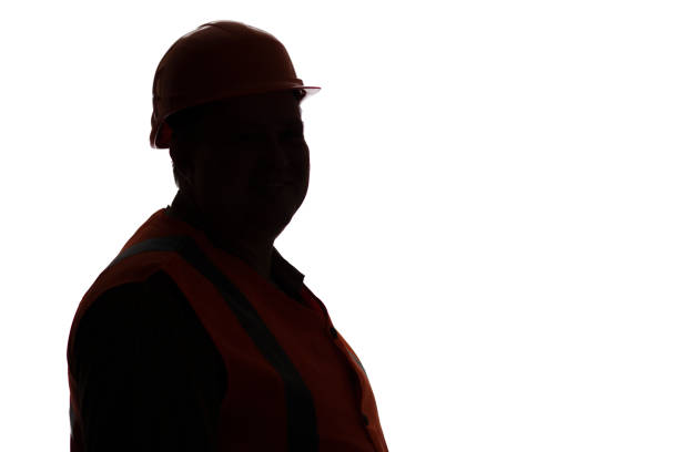istock silhouette of middle-aged builder contractor in hard hat looking in camera on white isolated background, building industry concept 1313892622