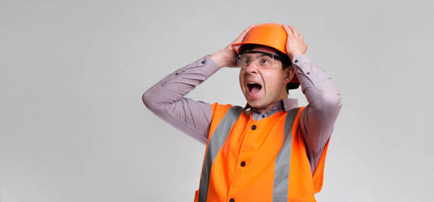 istock young engineer architect clutching his head in helmet on grey studio background, foreman shocked 1313893689