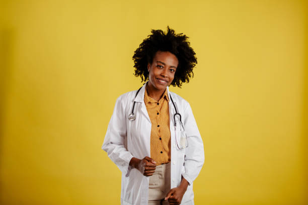 Beautiful African young woman wearing doctor uniform with a happy and cool smile on face. stock photo