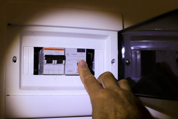 istock Man's hand by setting the light key on an electric power board, after a power outage. 1313898975
