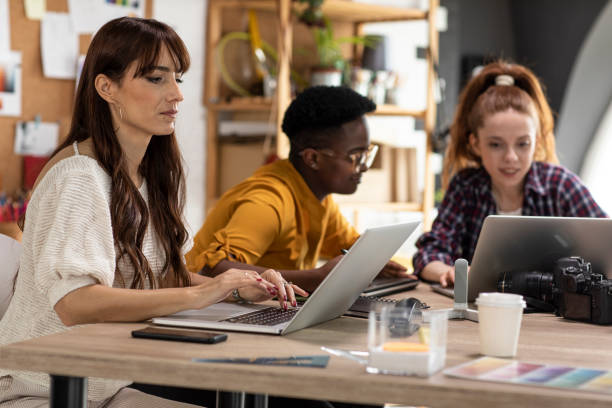 istock Creative woman typing a text on laptop while working with colleagues at the office 1313899087