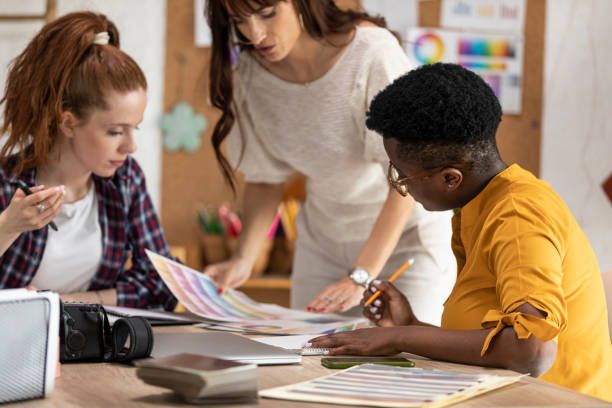 istock Graphic designers reviewing color charts while working on a project together 1313899457