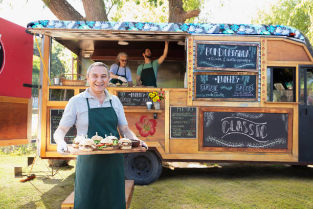 istock Senior man waiter serving food outside 1313900128