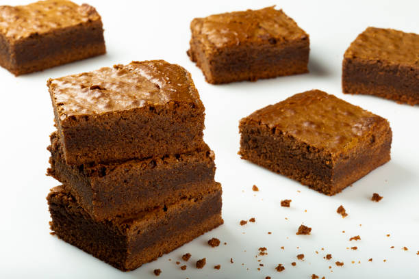 köstliche stücke von frischem brownie auf weißem hintergrund. schokoladenkuchen. - cupcake chocolate icing candy stock-fotos und bilder