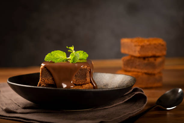 schokoladen-brownies mit schokoladensauce und minzblättern. - cupcake chocolate icing candy stock-fotos und bilder