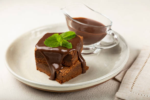 istock Chocolate brownies with chocolate sauce and mint leaves. 1313907179