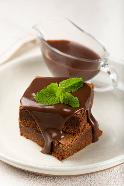 istock Chocolate brownies with chocolate sauce and mint leaves. 1313907183