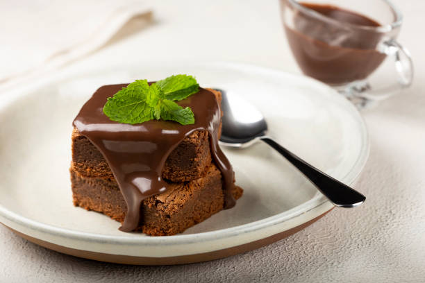istock Chocolate brownies with chocolate sauce and mint leaves. 1313907201