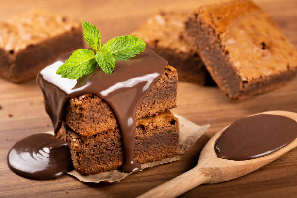 schokoladen-brownies mit schokoladensauce und minzblättern. - cupcake chocolate icing candy stock-fotos und bilder