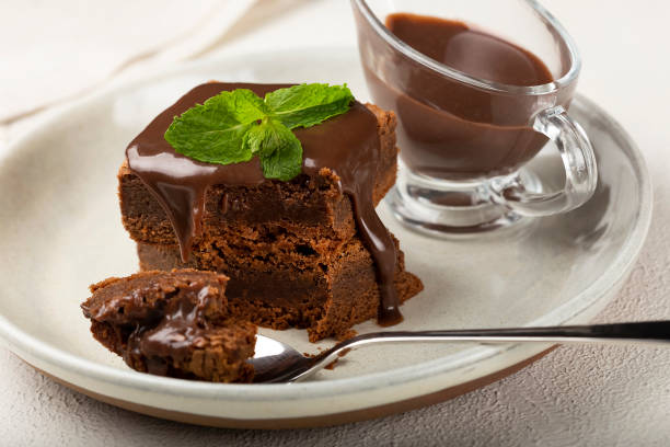 istock Chocolate brownies with chocolate sauce and mint leaves. 1313907231