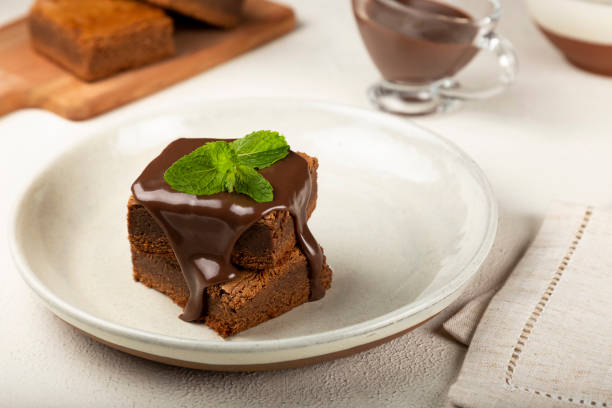 istock Chocolate brownies with chocolate sauce and mint leaves. 1313907246