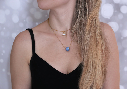 blonde woman wearing gold necklaces - greek jewelry