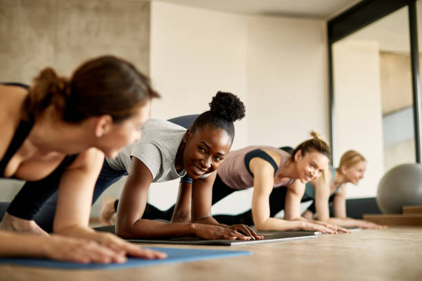 istock Happy African American athlete talking to her friend while stretching on exercise class in health club. 1313909864