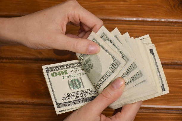 istock Woman hands counting us dollar banknotes 1313911702