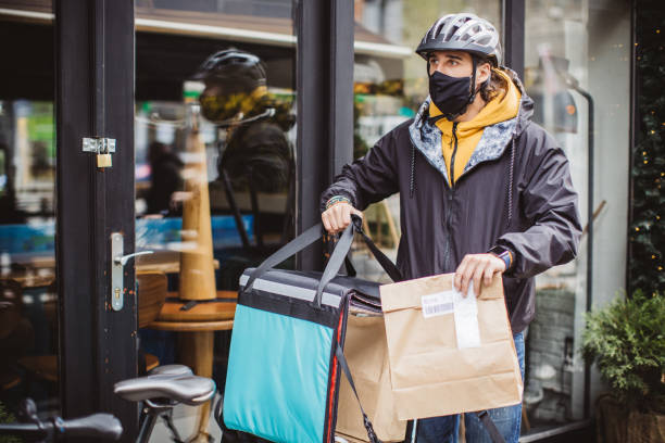 istock Delivery man picking up take away food order 1313913975