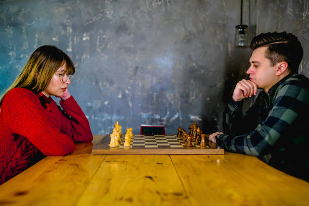 femme et homme jouant aux échecs - chess skill concentration intelligence photos et images de collection