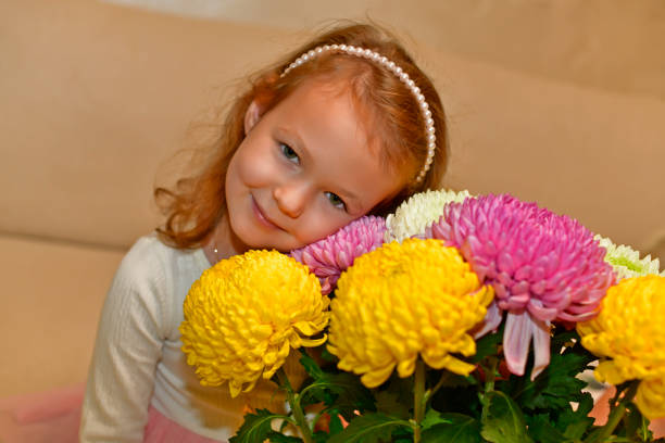 The little girl is holding a rapeseed flower