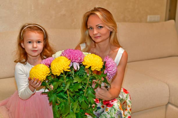 Happy daughter  giving bouquet of tulips to her mother for mother's day.