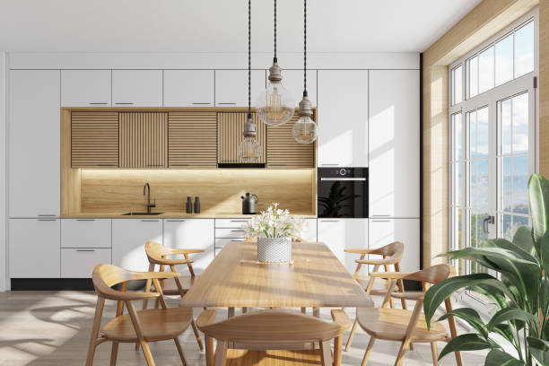 istock White and light wood Modern Scandinavian kitchen with large dining table and chairs. Large windows. Open space kitchen concept. Summer scene. 1313916715