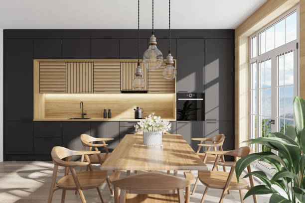 istock Black and light wood Modern Scandinavian kitchen with large dining table and chairs. Large windows. Open space kitchen concept. Summer scene. 1313916743