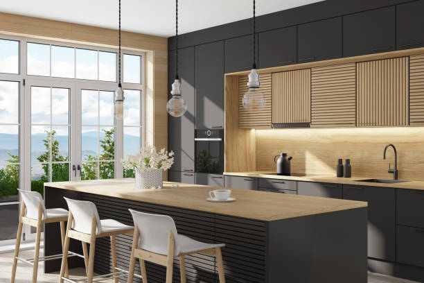 istock Black and light wood Modern Scandinavian kitchen with large kitchen island with stools. Large windows. Open space kitchen concept. Summer scene. 1313916949